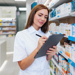 Foto: Eine PTA/PKA/Apothekerin im Lager notiert etwas auf einem Klemmbrett.