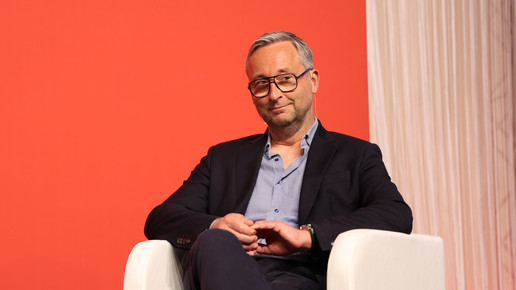 Manager Olaf Heinrich auf einem weißen Stuhl.