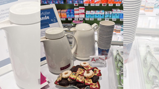 Kannen und Gebäck auf einem Tisch in einer Apotheke.