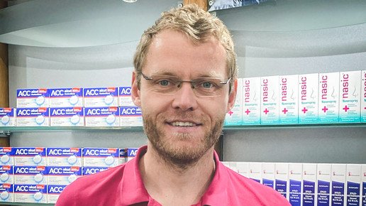 Foto: Apotheker Jörn Graé lächelnd vor der Sichtwahl seiner Apotheke. Mehr dazu im Artikel.
