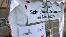 Zelt mit Poster „Corona-Schnelltest-Zentrum im Nordbezirk“.