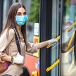 Frau mit Maske steigt in den Bus