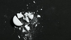 Eine gebrochene weiße Pille auf schwarzem Hintergrund - Makrofoto - Konzept der Medizin und der Medikation, Gesundheitsversorgung