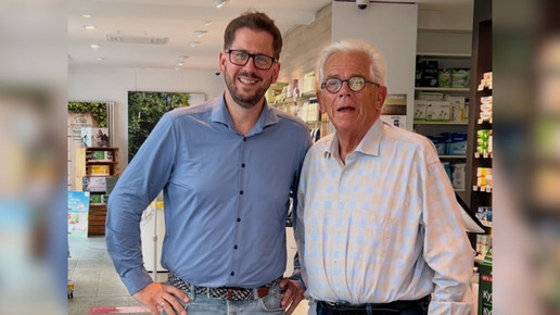 Ein Apotheker und sein Sohn stehen in der Apotheke.