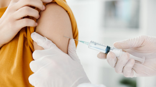 Foto: Eine Person verabreicht eine Spritze im Oberarm.