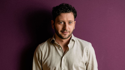 Felix Banaszak von den Grünen vor lila Hintergrund.