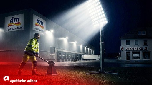 Montage einer Person, die einen Strahler vor einem DM-Logistikzentrum einschaltet.