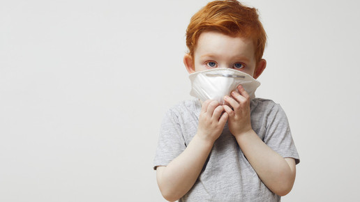 Rothaariger Junge trägt Atemschutzmaske