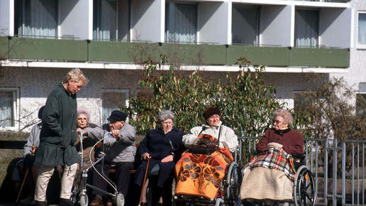 Senioren im Rollstuhl vor Pflegeheim