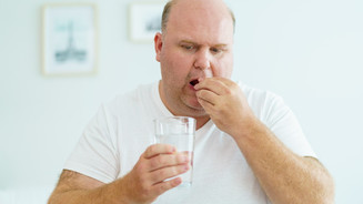 Mann nimmt Tablette ein