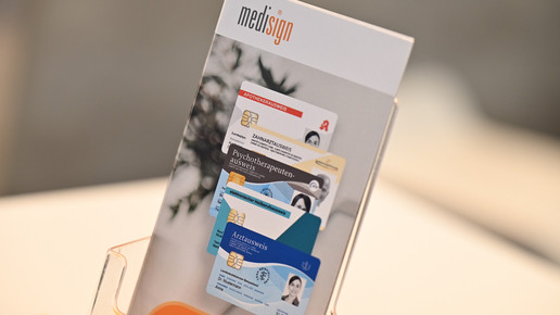 Foto: Ein Flyerständer zu elektronischen Ausweisen von Medisign auf der DMEA 2023