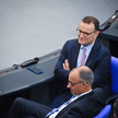 Jens Spahn 2025 im Bundestag sitzend, locker im Gespräch mit Friedrich Merz