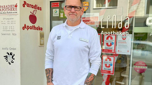 Dirk Vongehr vor seiner Paradies-Apotheke mit Protest-Material an der Tür