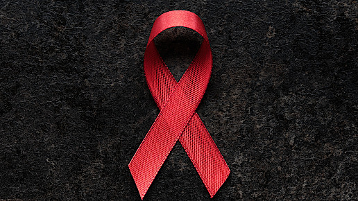 Aidsschleife dargestellt vor schwarzem Hintergrund.