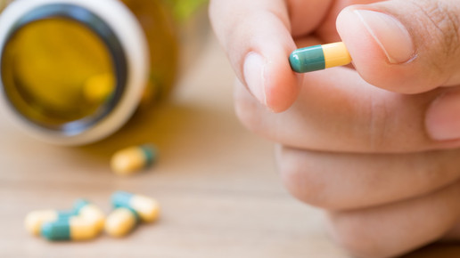 Foto: Eine Person hält eine Tramadol-Kapsel zwischen den Fingern.