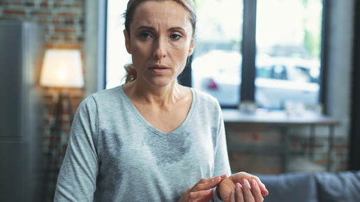 Frau im mittleren Alter, die schwitzt