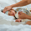 Foto: Ein Kleinkind liegt mit Fieber im Bett