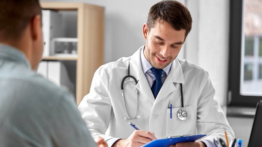 Foto: Ein Arzt ist im Gespräch mit seinem Patienten und notiert etwas.