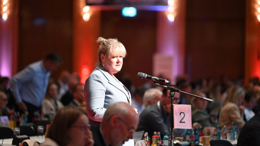 Claudia Korf von der Abda am Mikrofon im Saal des DAT