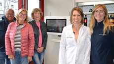 Mehrere Menschen stehen vor einem Apothekenterminal. Mehr dazu im Artikel.