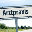 Symbolbild – Wegweiser, auf dem "Arztpraxis" steht