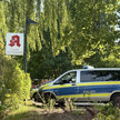 Ein Apotheken-A-Schild mit einem Polizeiwagen.