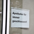 Symbolbild: Auf einer Fensterscheibe hängt ein Schild mit der Aufschrift „Apotheke für immer geschlossen“.