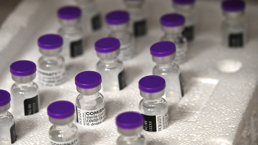 Zahlreiche Comirnaty-Vials in Reihe, stabilisiert durch Styropor.