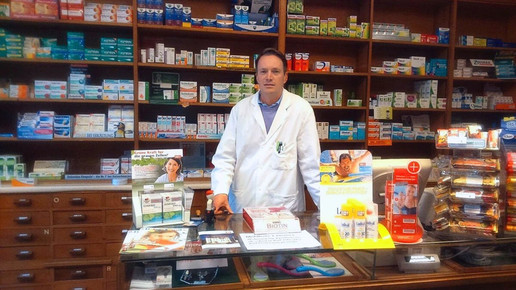 Apotheker Christopher Hummel im Kittel in seiner Apotheke