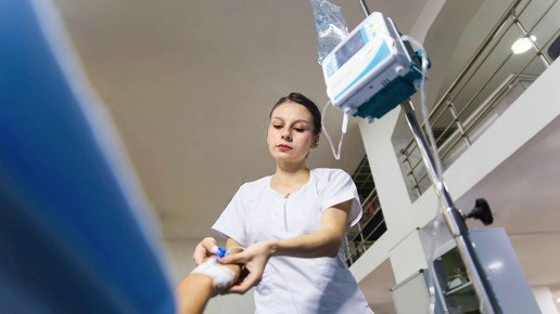 Pflegekraft kümmert sich zum Infusion und Zugang an der Hand