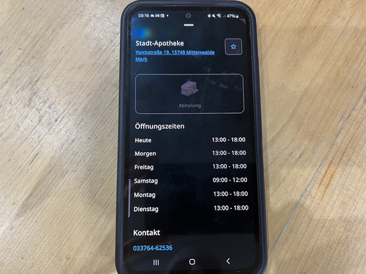 Foto: Ein Handy auf einem Holztisch mit geöffneter E-Rezept-App der Gematik.