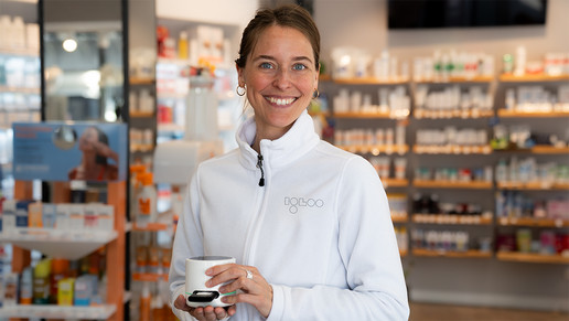 Eine Goodscare-Testexpertin präsentiert das kompakte Igloo-Testgerät in einer Apotheke. Das kleine Point-of-Care-System wird in den Händen gehalten und ist für diagnostische Schnelltests direkt vor Ort vorgesehen.
