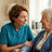 Eine Ärztin oder eine Pflegerin zum Hausbesuch bei einer Seniorin