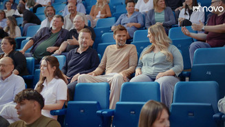 Screenshot aus dem Werbevideo von Novo Nordisk mit Jürgen Klopp im Fußballstadion sitzend zwischen kranken Fans