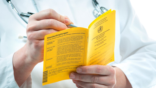 Arzt trägt in Impfbuch ein