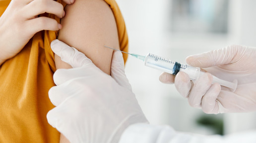 Foto: Eine Person verabreicht eine Spritze im Oberarm.